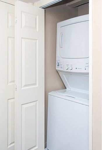 A white microwave oven is installed in a white door.